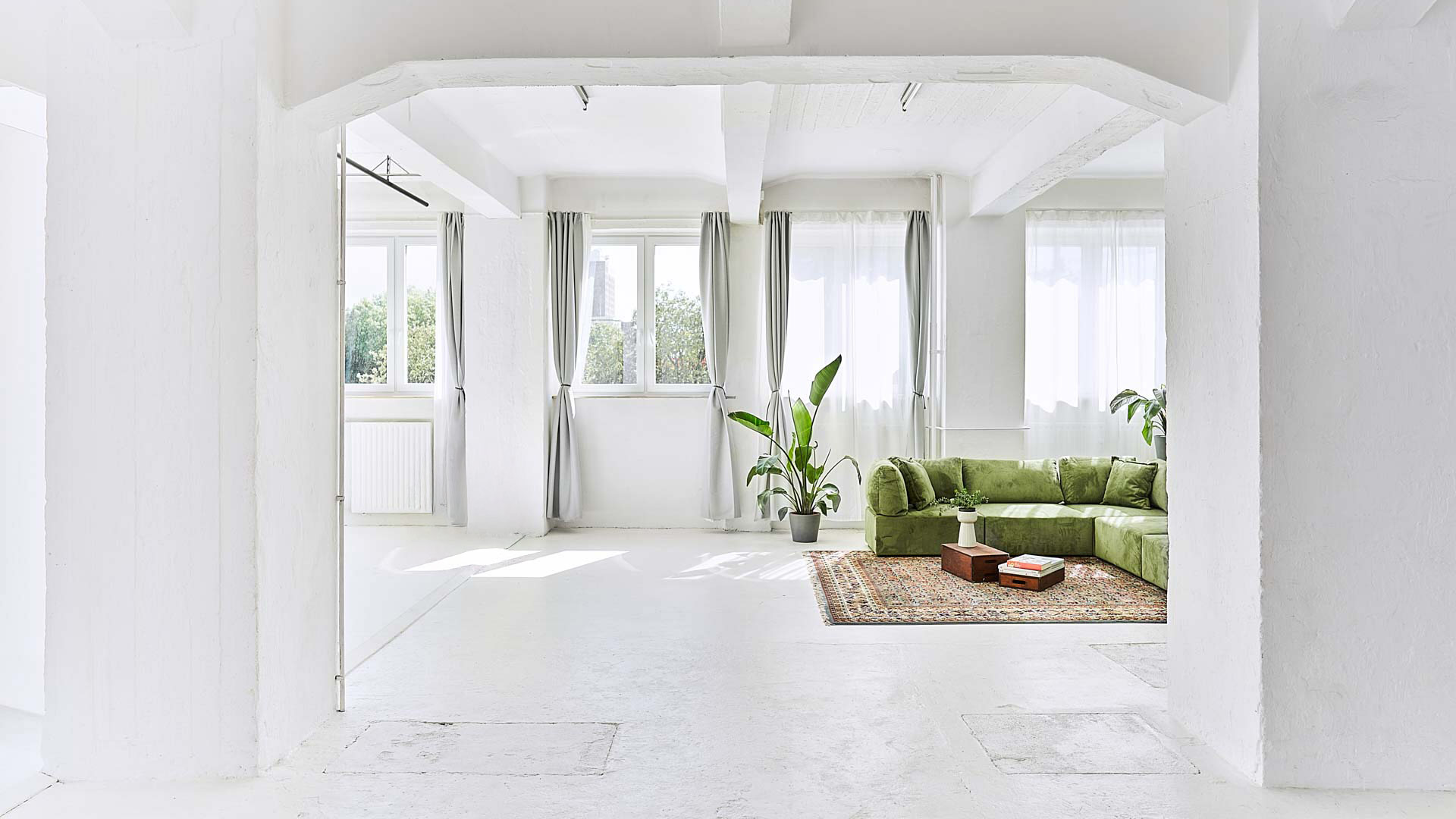 Tageslicht über Fenster im Mietstudio mit grünem Sofa